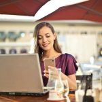 woman wearing purple shirt holding smartphone white sitting on chair